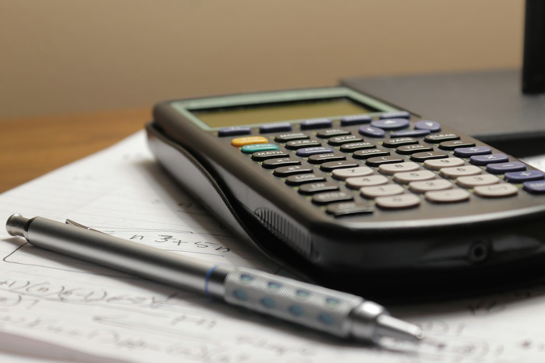 Calculator and pen resting on paper, illustrating a check of balance figures.