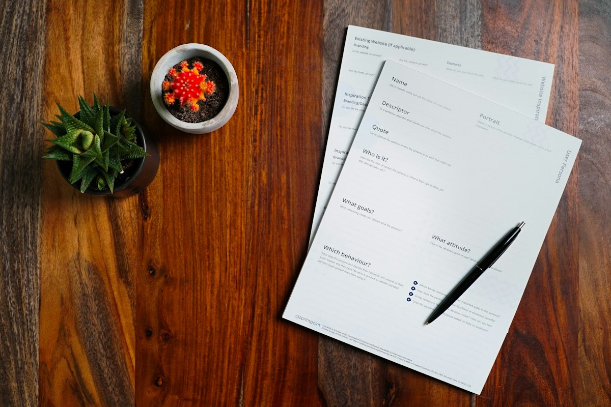 Papers and a pen on a wooden table, illustrating a document check.