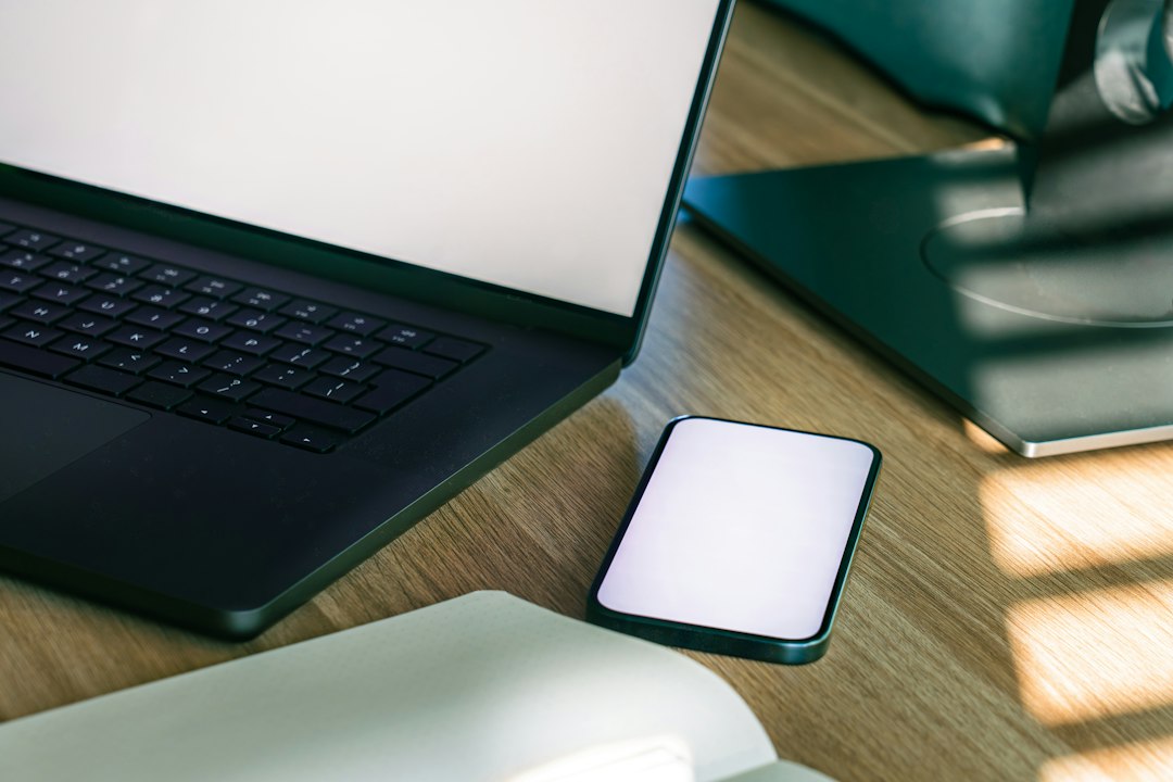 Smartphone beside a laptop on a desk, illustrating online redemption method selection.